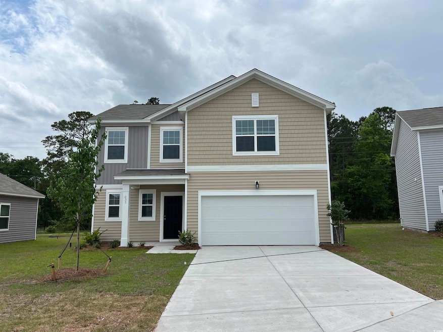 Traditional home with a front yard, concrete drive