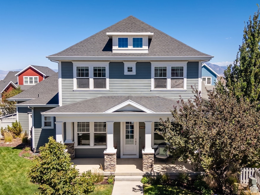 American foursquare style home featuring a porch, roof with shingles, stone siding, and a mountain view