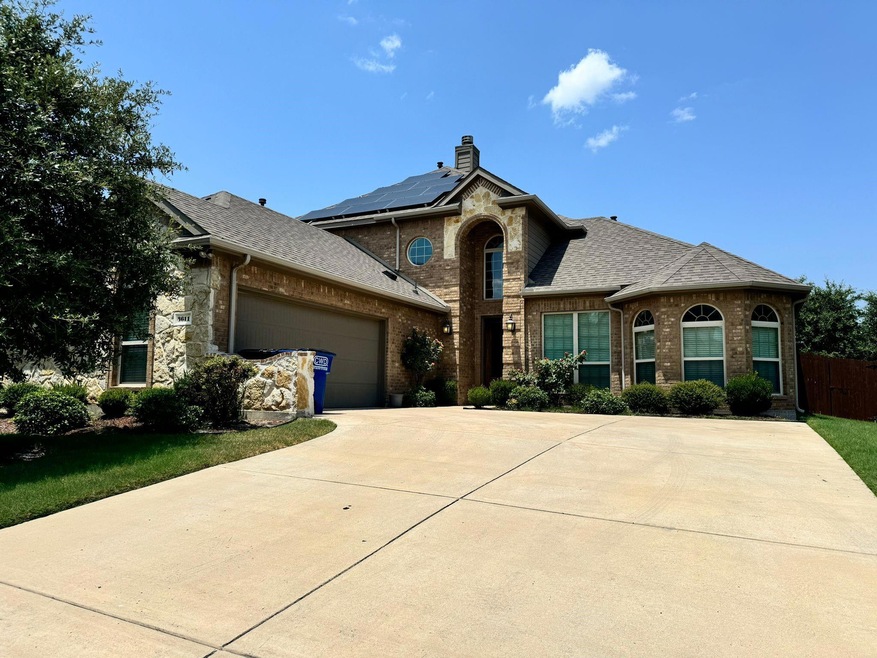 View of front facade featuring a garage and solar panels