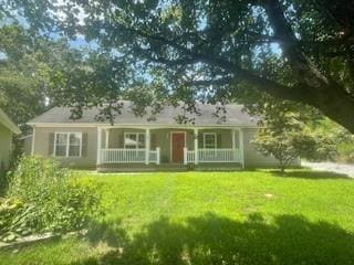 Single story home with a porch and a front yard