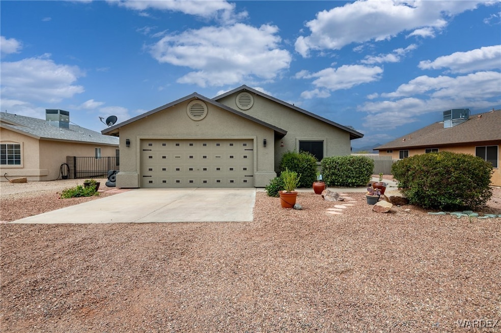 Ranch-style home with a garage, stucco siding, fen