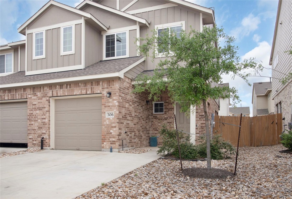 View of front facade featuring a garage, brick si