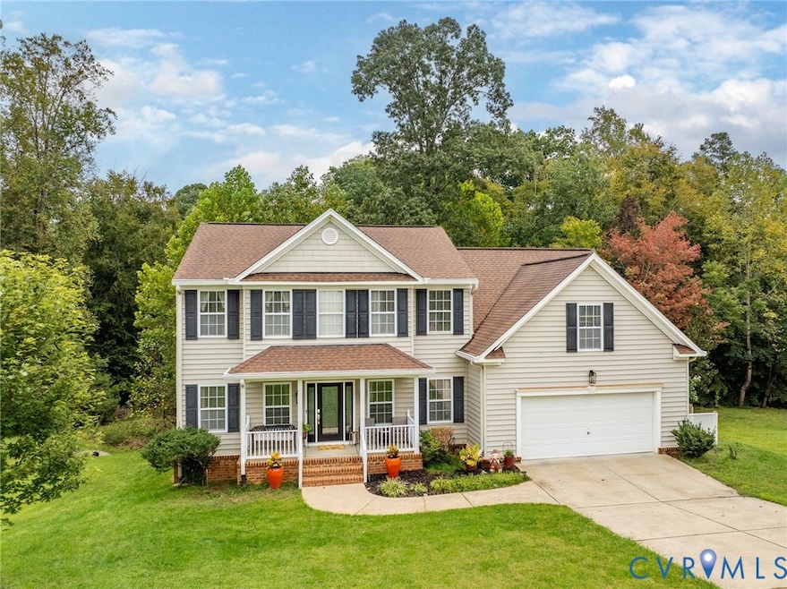 Colonial inspired home with a front lawn, covered porch, roof with shingles, and concrete driveway