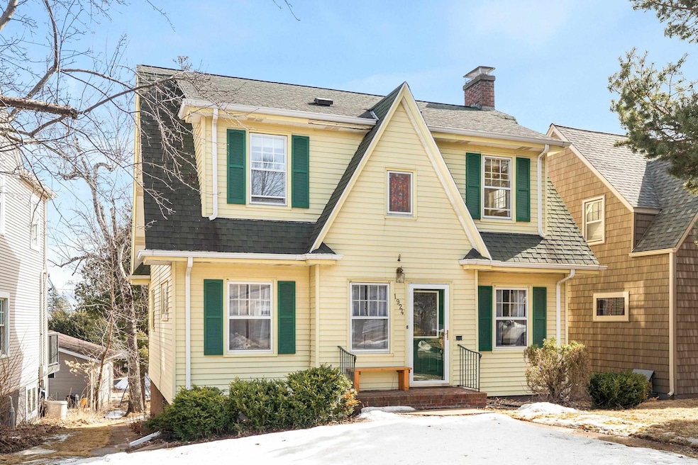 View of front of property with roof with shingles and a chimney