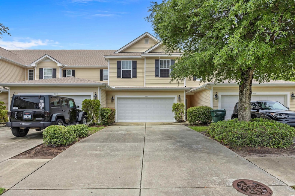 Traditional-style house featuring concrete driveway, a garage, and a shingled roof