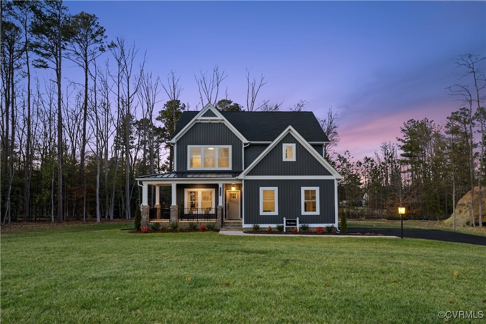 Craftsman-style home featuring a standing seam roof, a porch, and a lawn