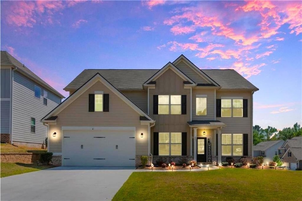 Craftsman-style house with concrete driveway, board and batten siding, a lawn, a garage, and stone siding