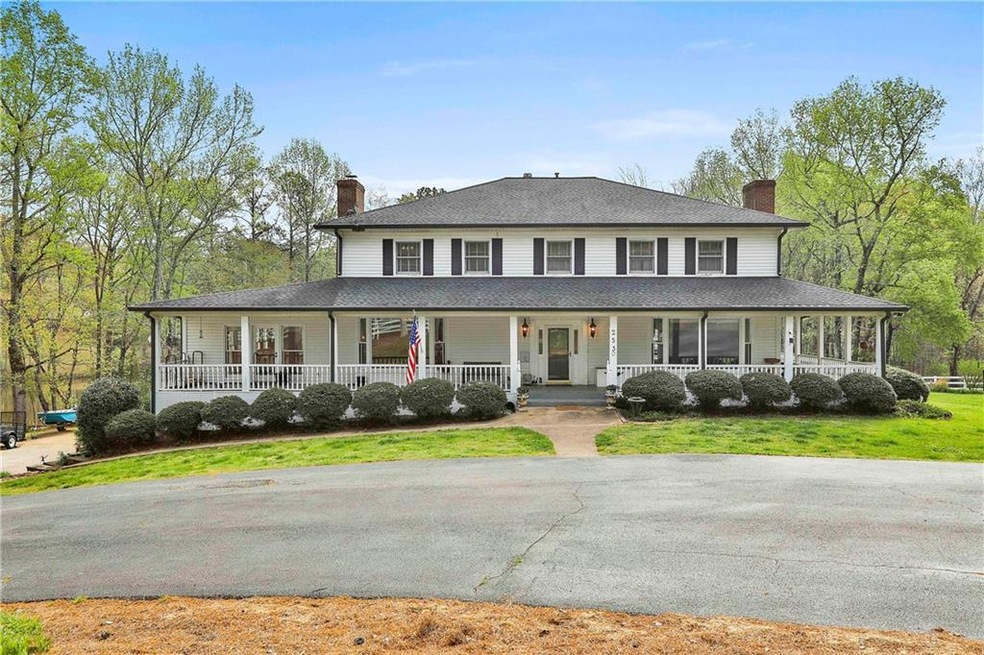 Farmhouse featuring covered porch and a front yard