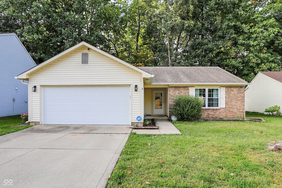 single story home featuring brick siding, driveway, a front lawn, roof with shingles, and an attached garage