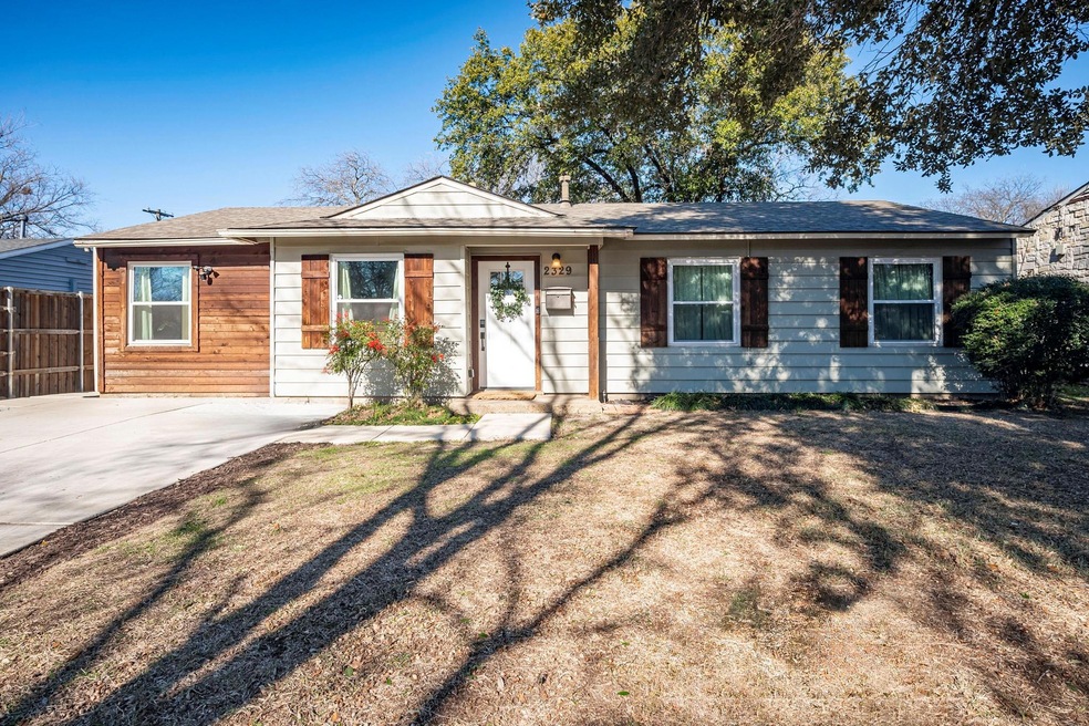 Large front yard with mature tree.