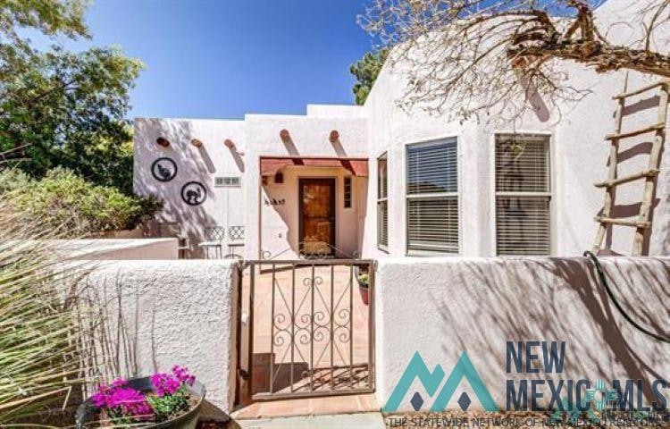 View of exterior entry with stucco siding and a gate