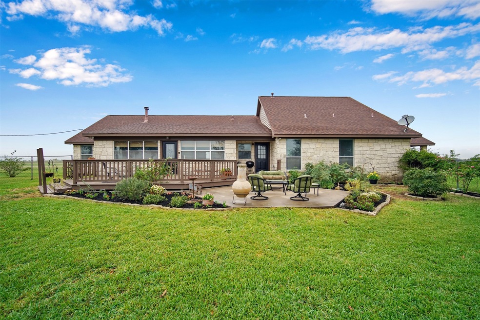 Rear view of home with large pation and fenced bac