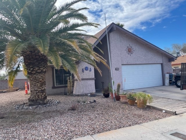 View of side of property featuring concrete drivew