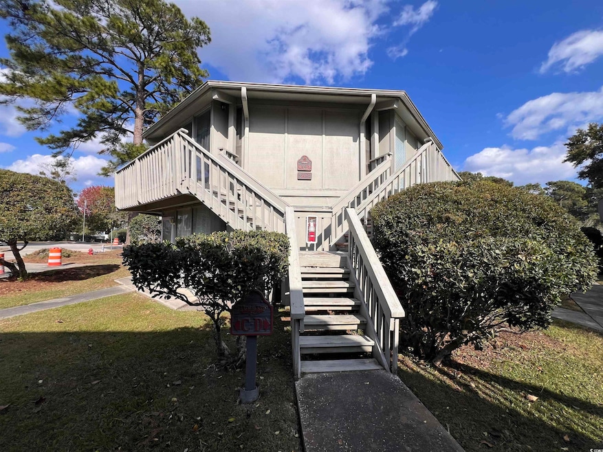 View of property exterior with stairway and a yard