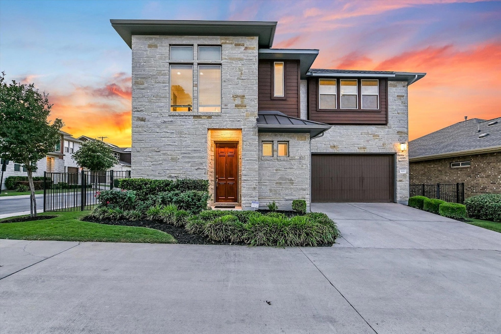 Contemporary house with stone siding, fence, a ga