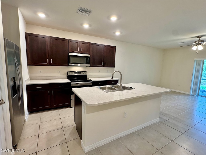 Kitchen featuring stainless steel appliances, visible vents, a sink, and light tile patterned flooring