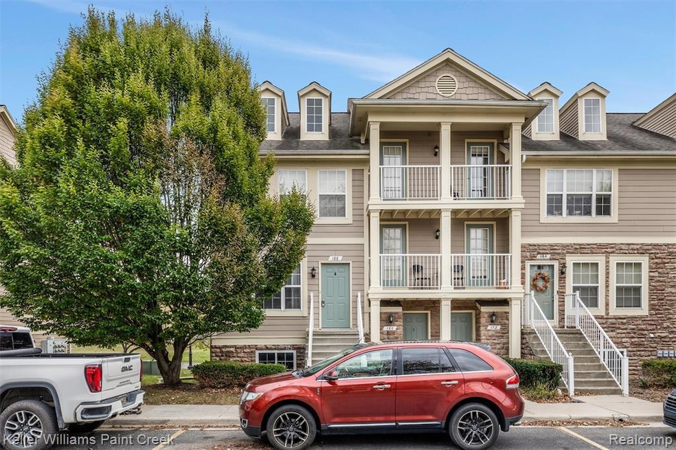 View of front of house featuring stone siding and a shingled roof