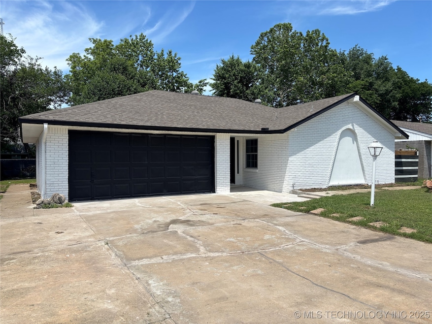 Ranch-style house with brick siding, a garage, dri