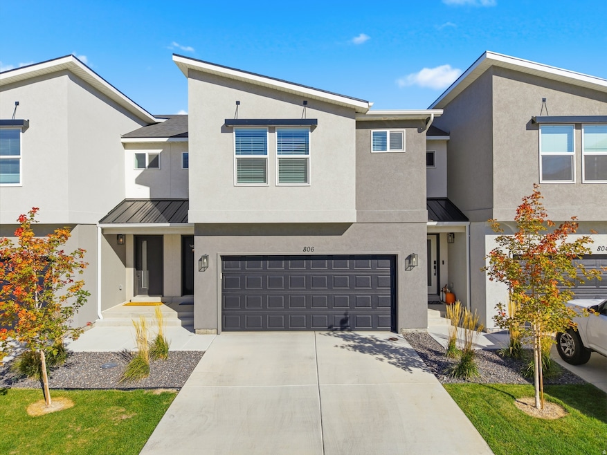 View of front of house with a standing seam roof, a metal roof, and stucco siding
