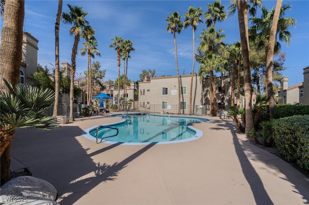 Community pool featuring a patio, fence, and a res