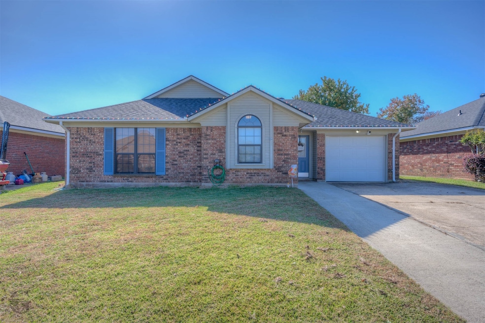 Ranch-style home with driveway, a garage, a front lawn, roof with shingles, and brick siding