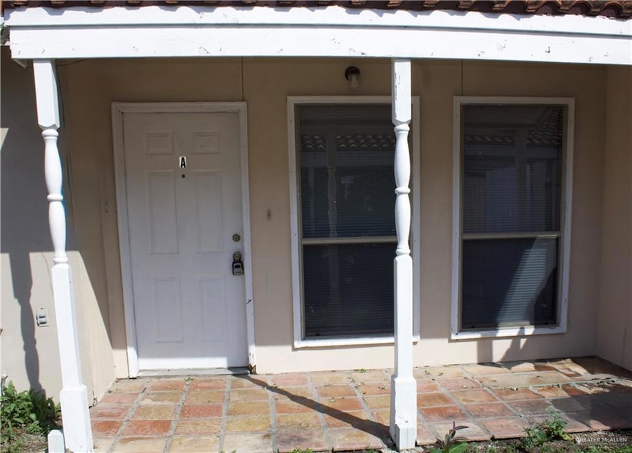 Property entrance featuring a tile roof and stucco siding