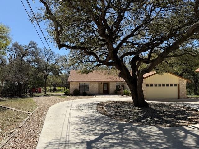 View of front of property featuring a garage, bri