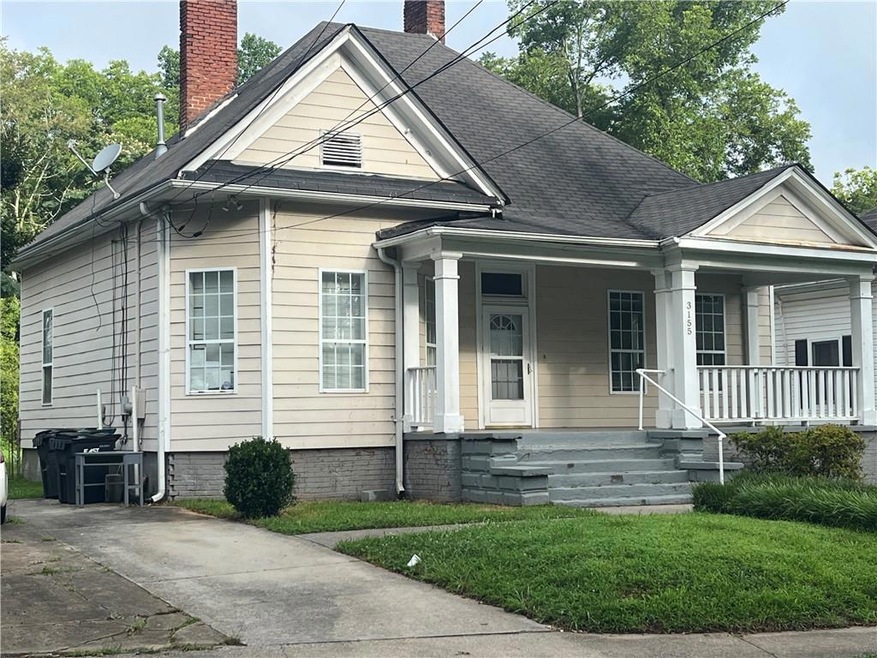 View of front of house featuring a chimney and a porch