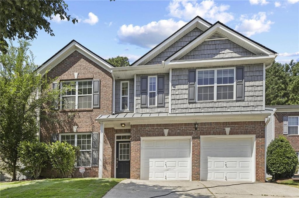 View of front of property with concrete driveway, a garage, brick siding, and a front yard