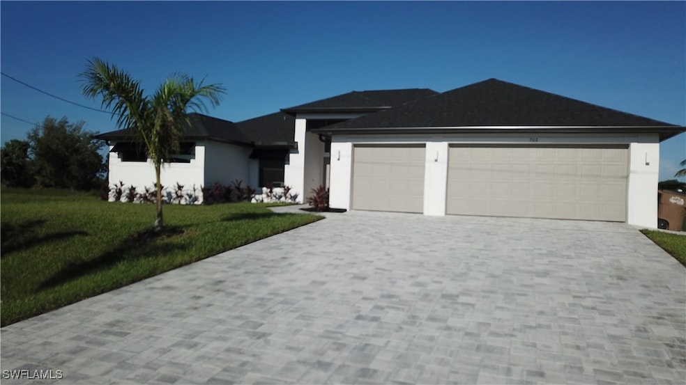 View of front of home with a garage and a front ya