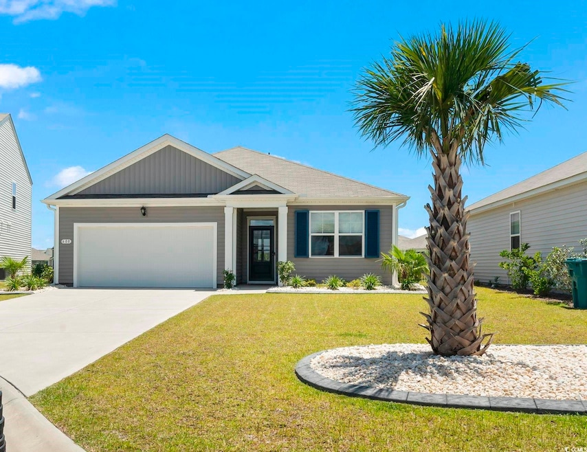 View of front of property with a garage, driveway, and a front yard