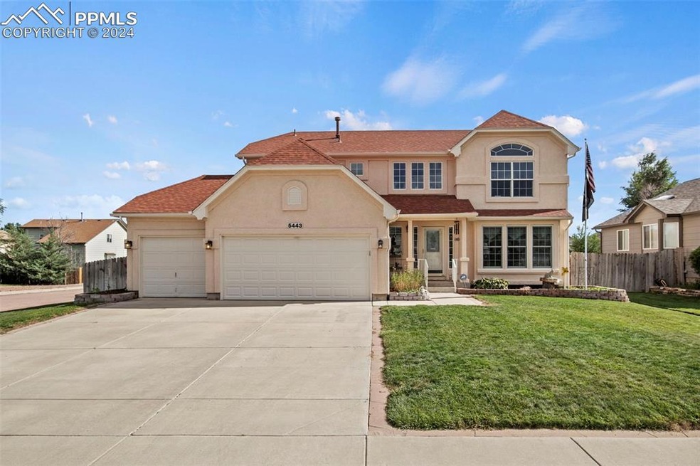 View of front of house with a garage and a front y