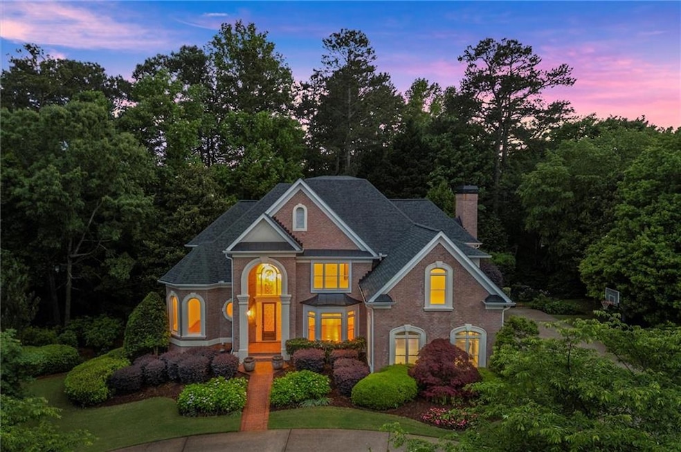 View of front of house with brick siding, a chimney, and a shingled roof