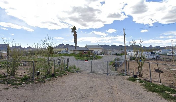 View of dirt / gravel road featuring a gated entry