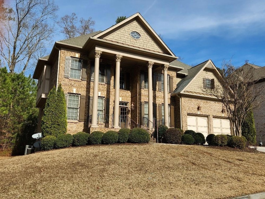 Neoclassical / greek revival house featuring a garage and a front lawn