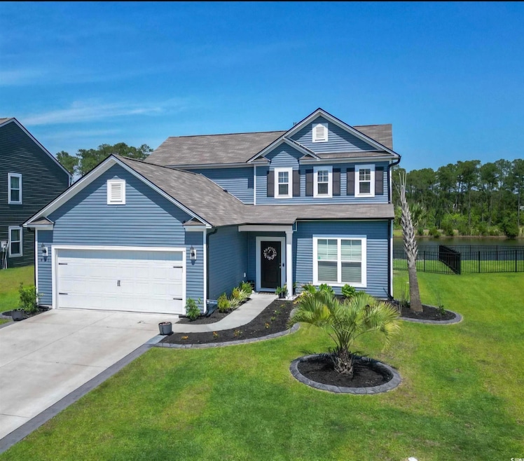 Traditional home with concrete driveway, a front yard, fence, and an attached garage