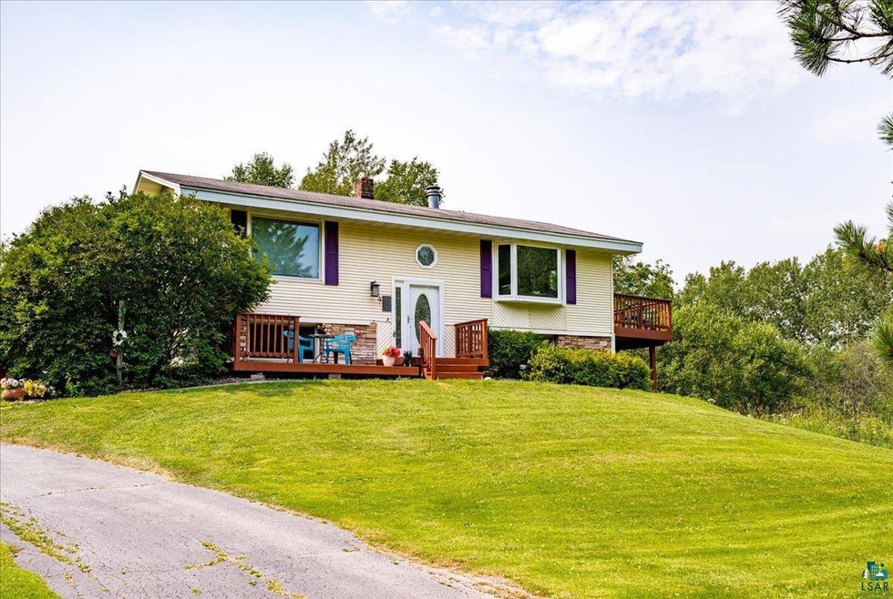 Split foyer home featuring a front lawn and a wood