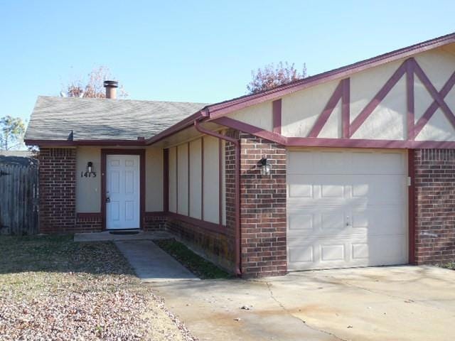 View of front of property with brick siding, a gar