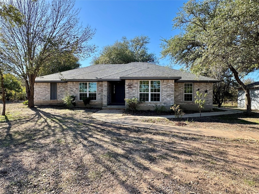 Ranch-style home featuring brick siding and roof with shingles