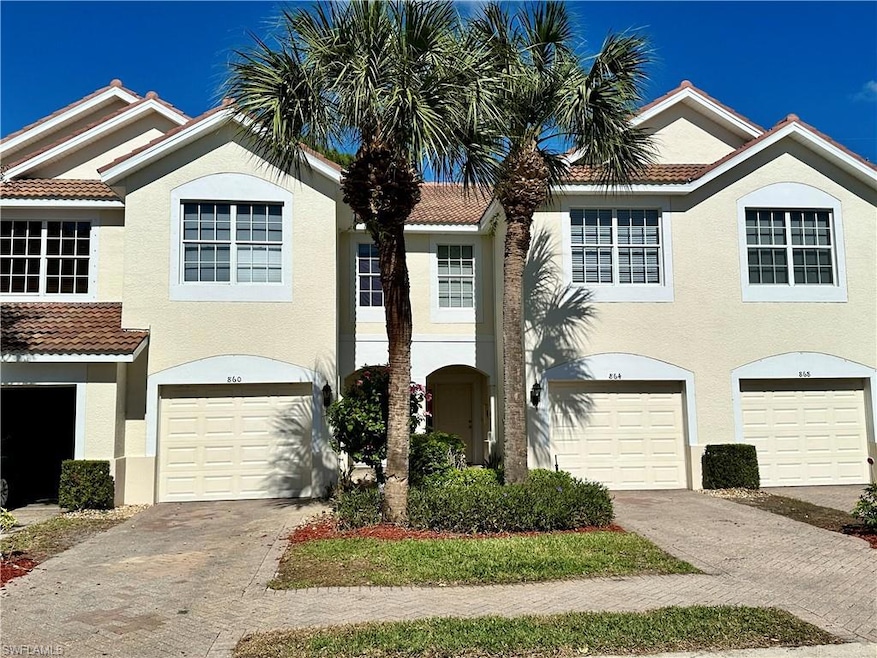 View of front of property with stucco siding, driveway, and a tiled roof