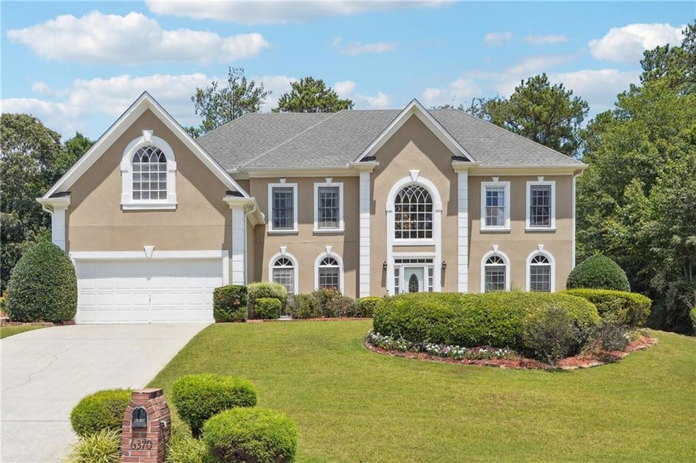 Colonial inspired home with a garage and a front y