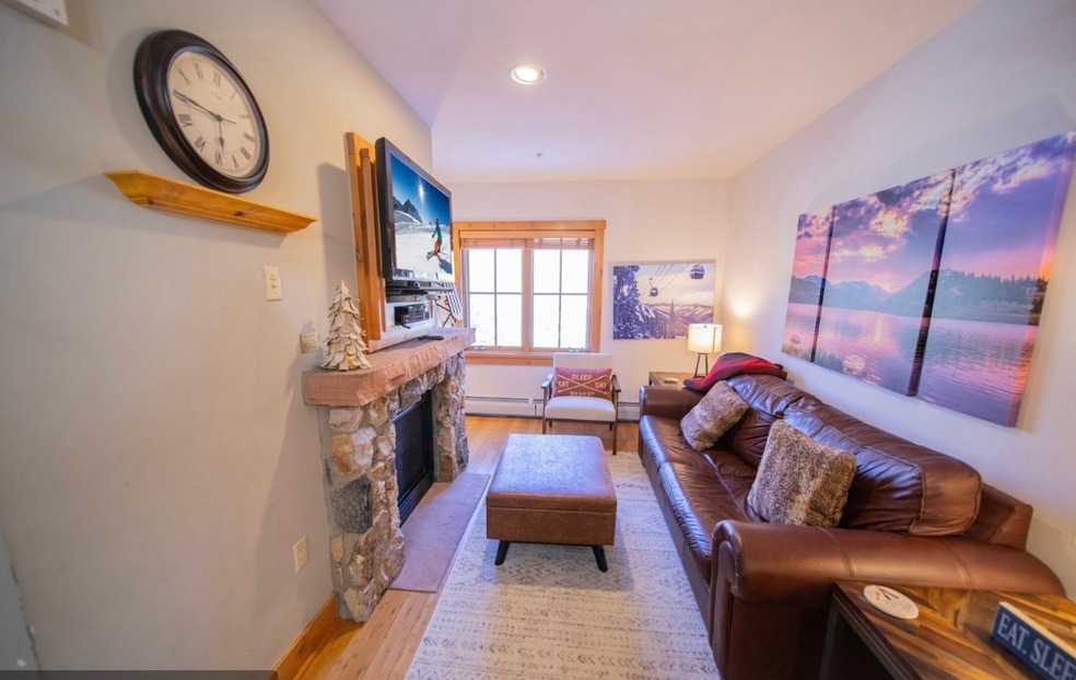 Living area with a stone fireplace, baseboard heat