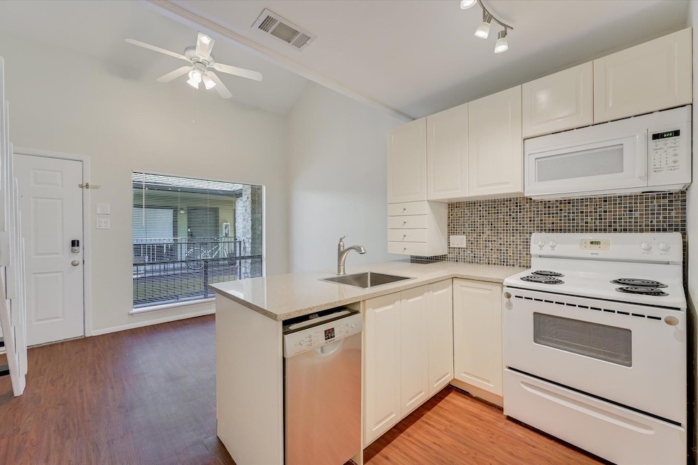 Kitchen featuring a peninsula, a sink, visible ve