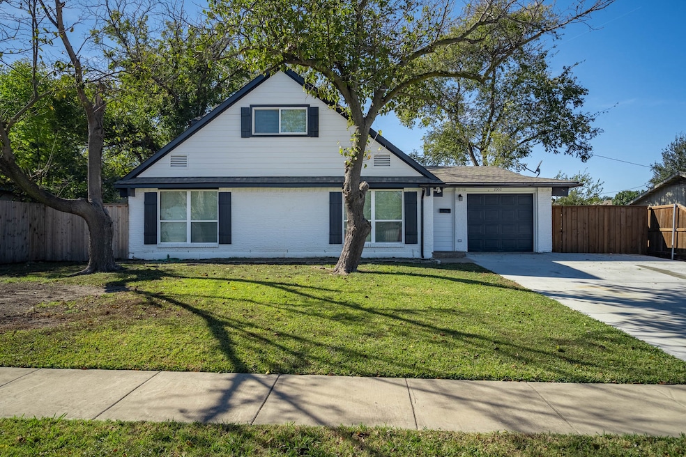 Traditional home with a garage, concrete driveway, and brick siding