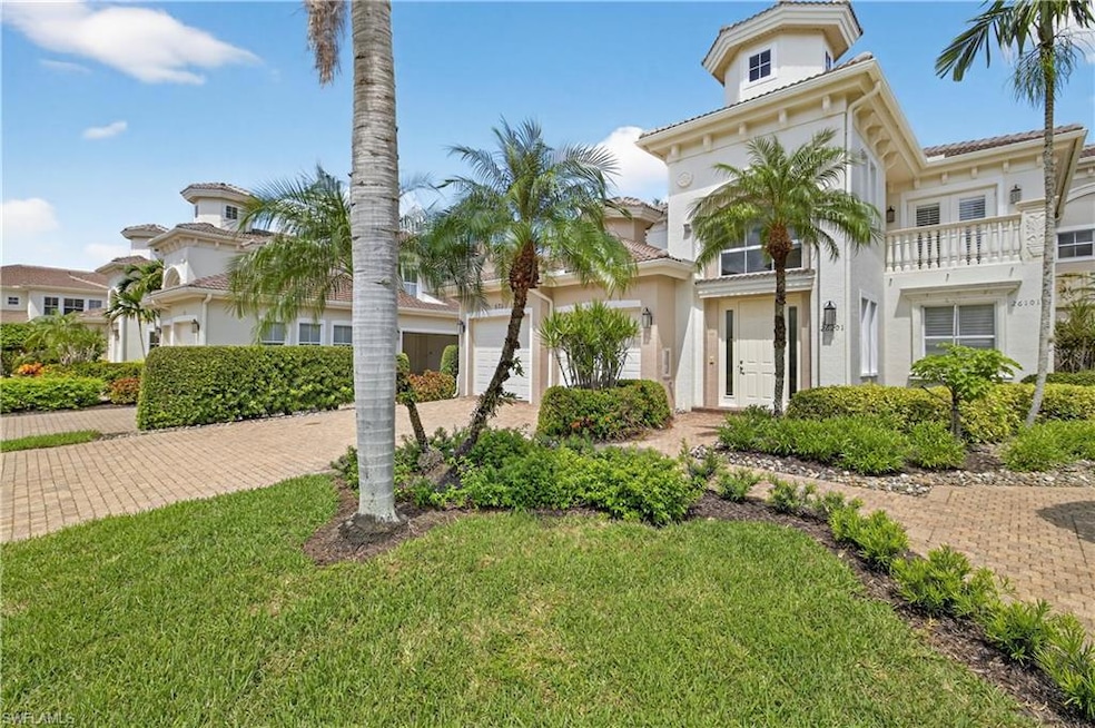 View of front of house featuring stucco siding, a front yard, a balcony, and decorative driveway