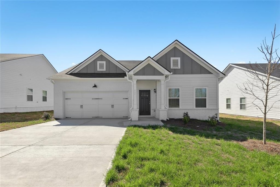 View of front of house with a front yard and a gar