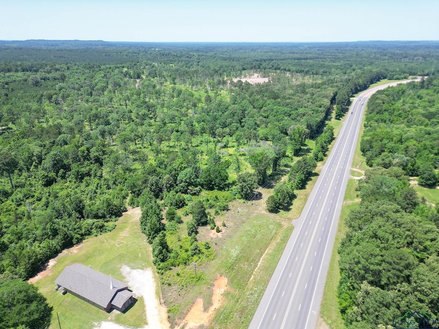 View of property location featuring a heavily wooded area and a major roadway