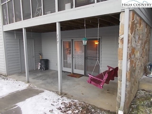 Outside of unit with covered balcony and porch swi