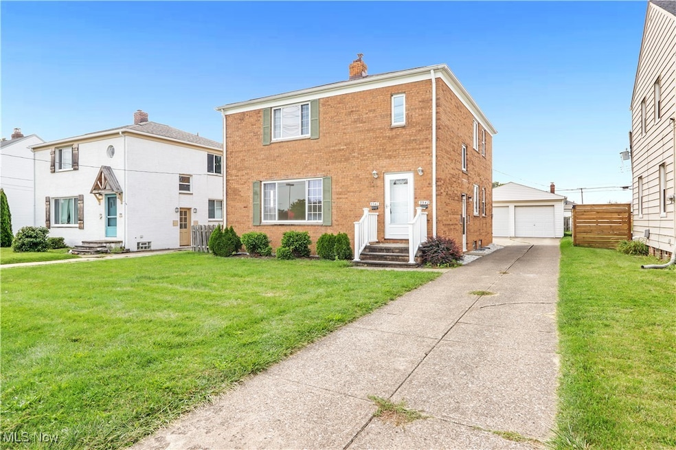 Traditional home with brick siding, a chimney, a garage, and an outbuilding