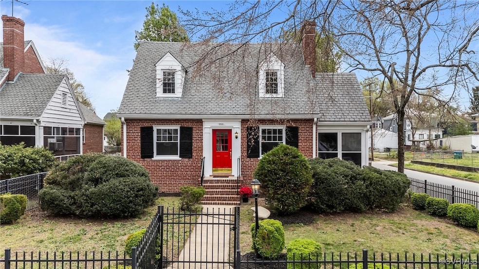 Cape cod house featuring brick siding, a front yar